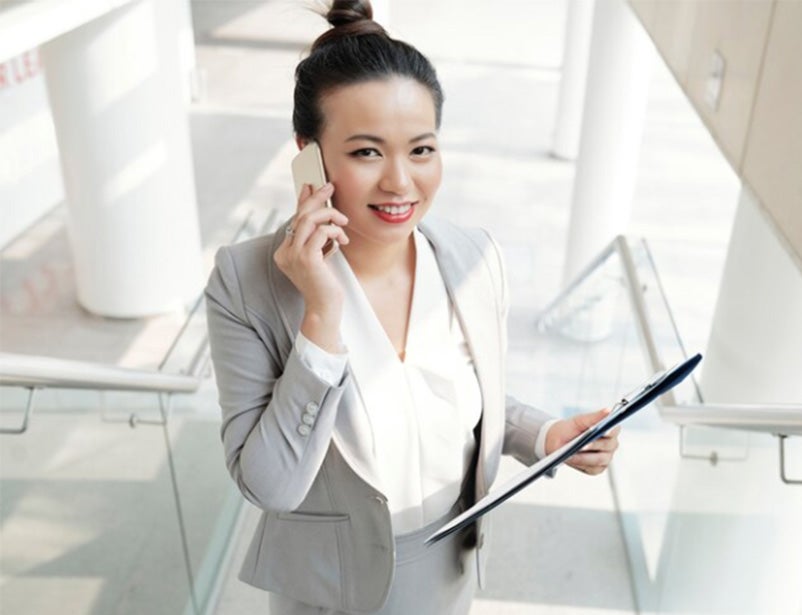 Image of a young woman on the phone in a building