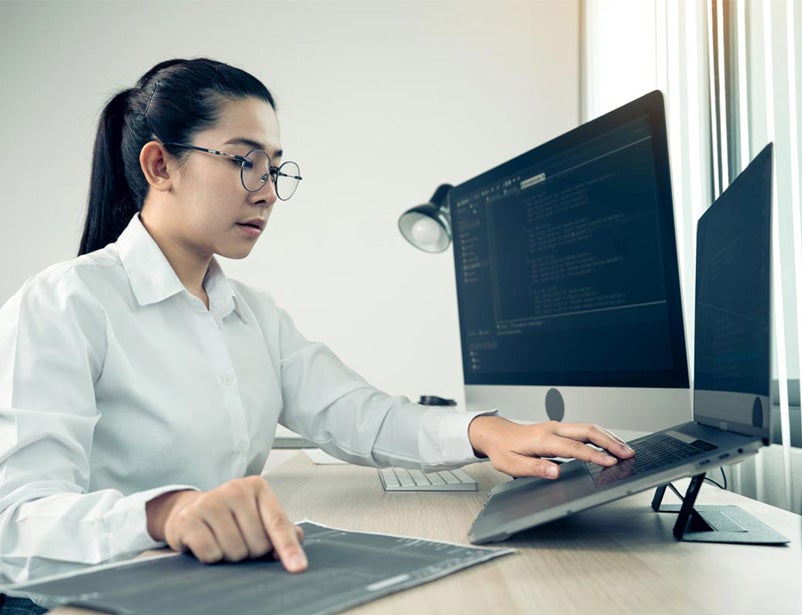 Woman on computer looking at cybersecurity